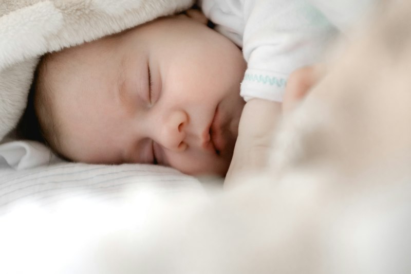 Bebé durmiendo protegido en habitación infantil libre de esporas de moho